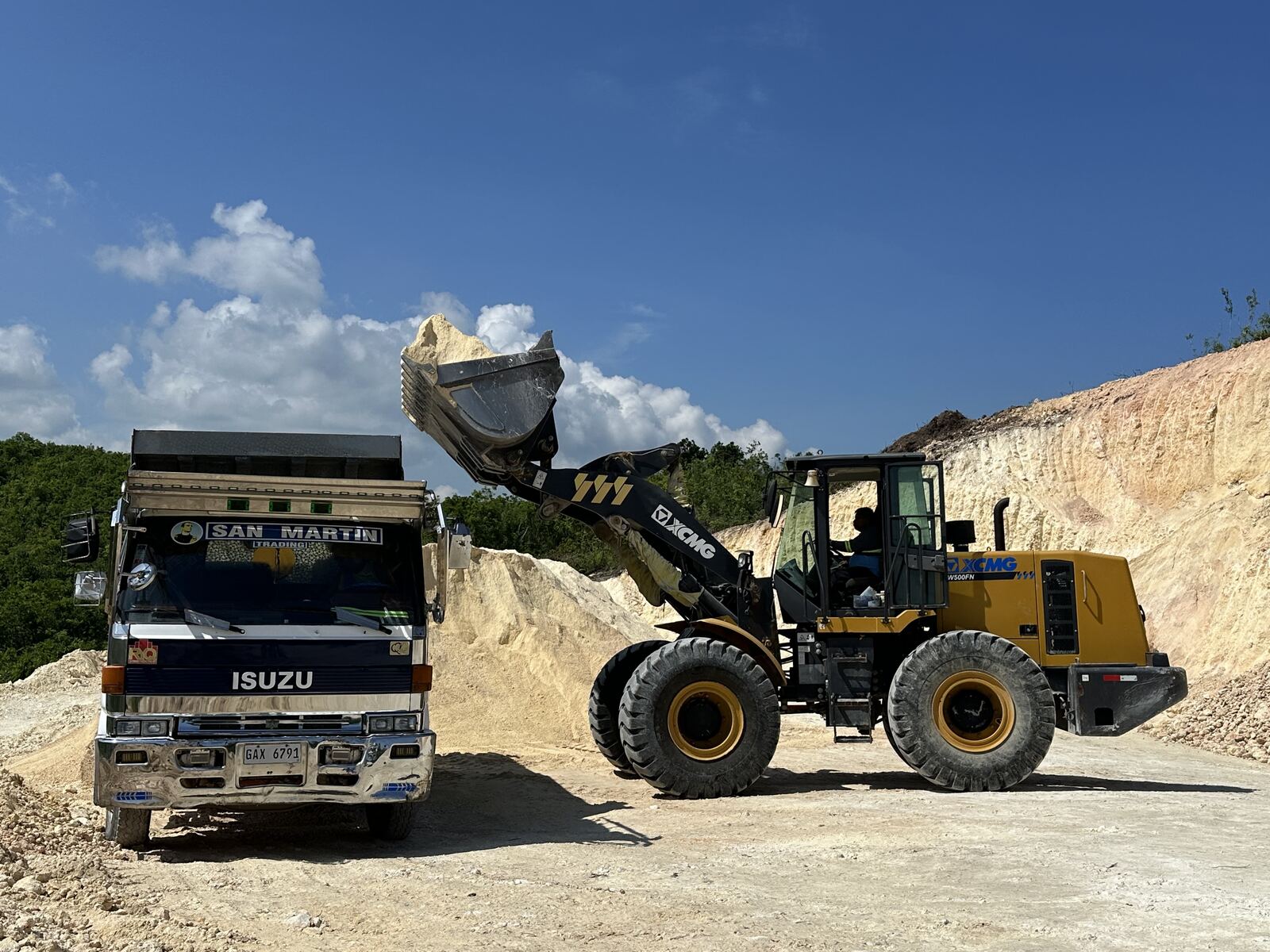 Wheel loader filling a dump truck with aggregates at the quarry