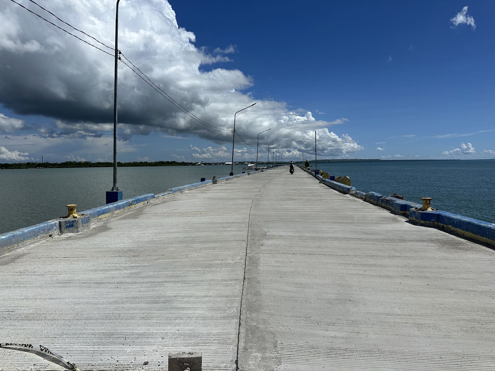 Newly completed concrete causeway extending over the sea
