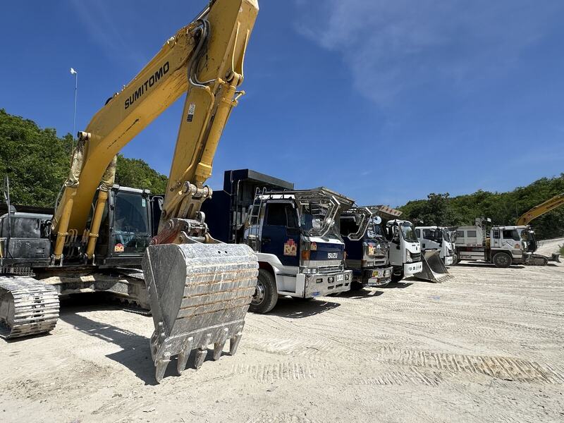 Excavator with trucks lined up behind