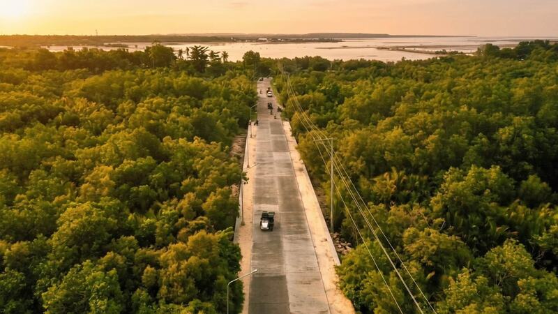 Coastal road at golden hour, aerial drone view